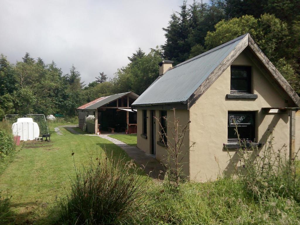 a small house with a barn in a yard at Castaway Cabin in Tuamgraney