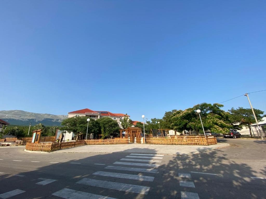 a parking lot with a fence and a street at Motel MontaNaro in Mostar