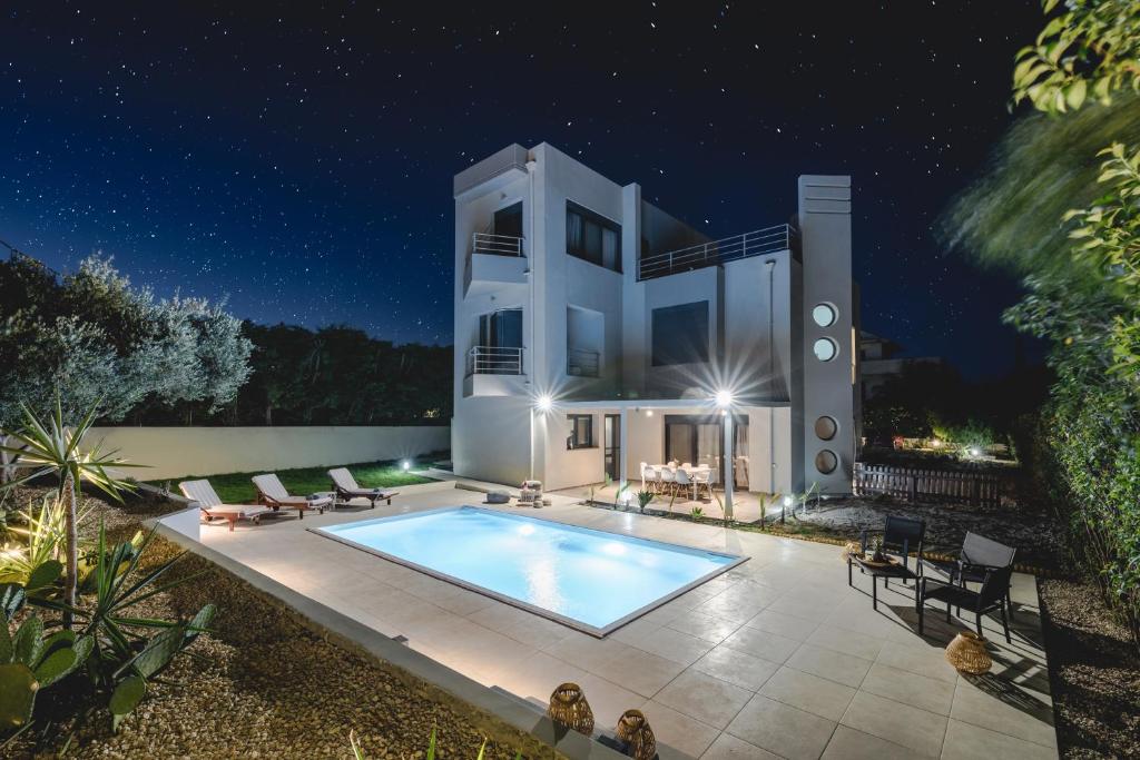 a villa with a swimming pool at night at Anssami Villa in Rhodes Town