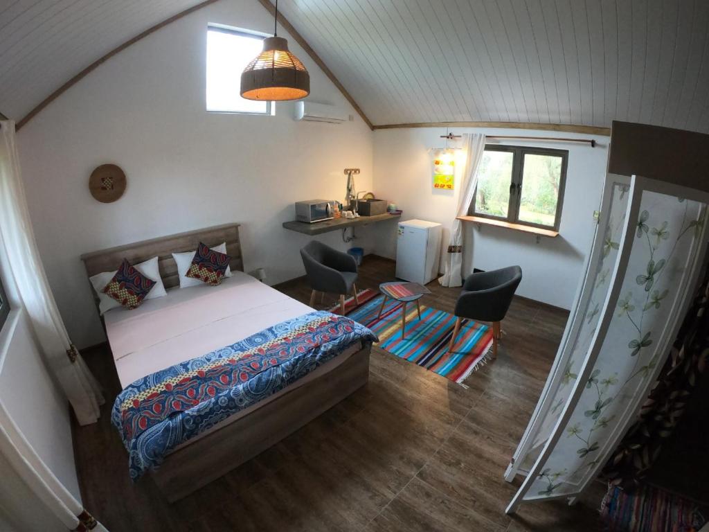 una camera con un letto e due sedie e una finestra di Coco room a Blue Bay
