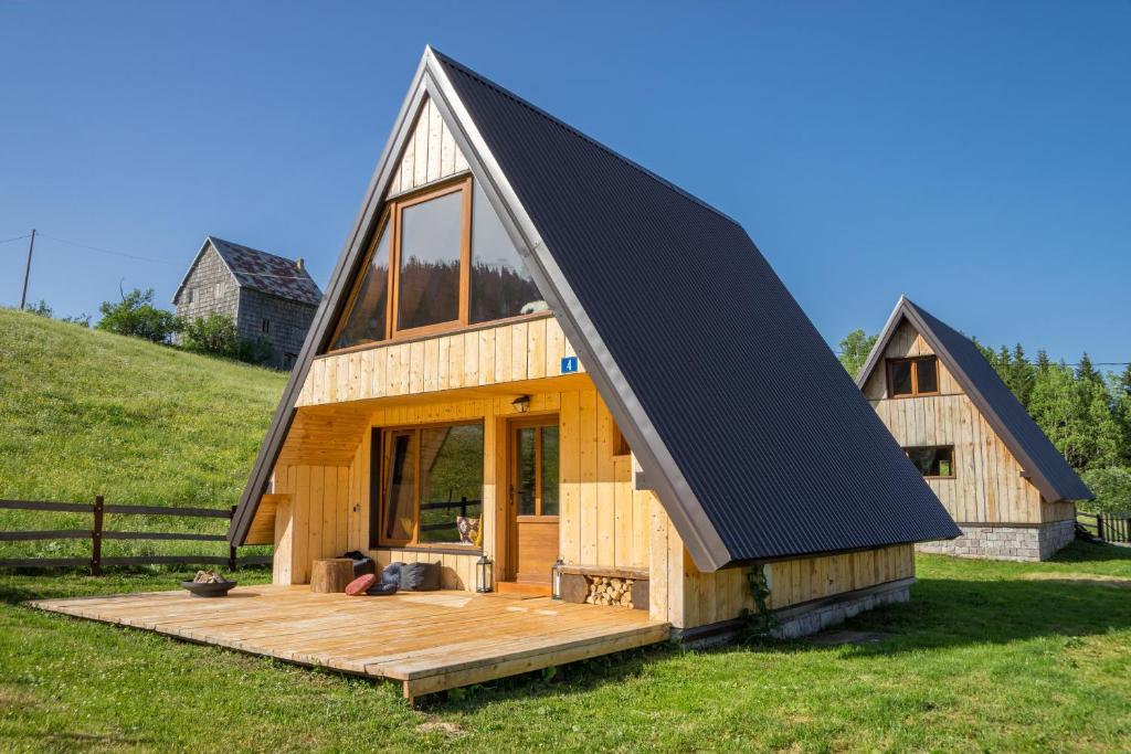 una gran casa de madera con techo negro en Chamois Apartments Durmitor, en Žabljak