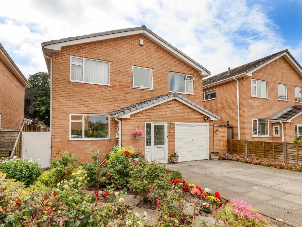 a brick house with a white garage at Spring Close in Southport