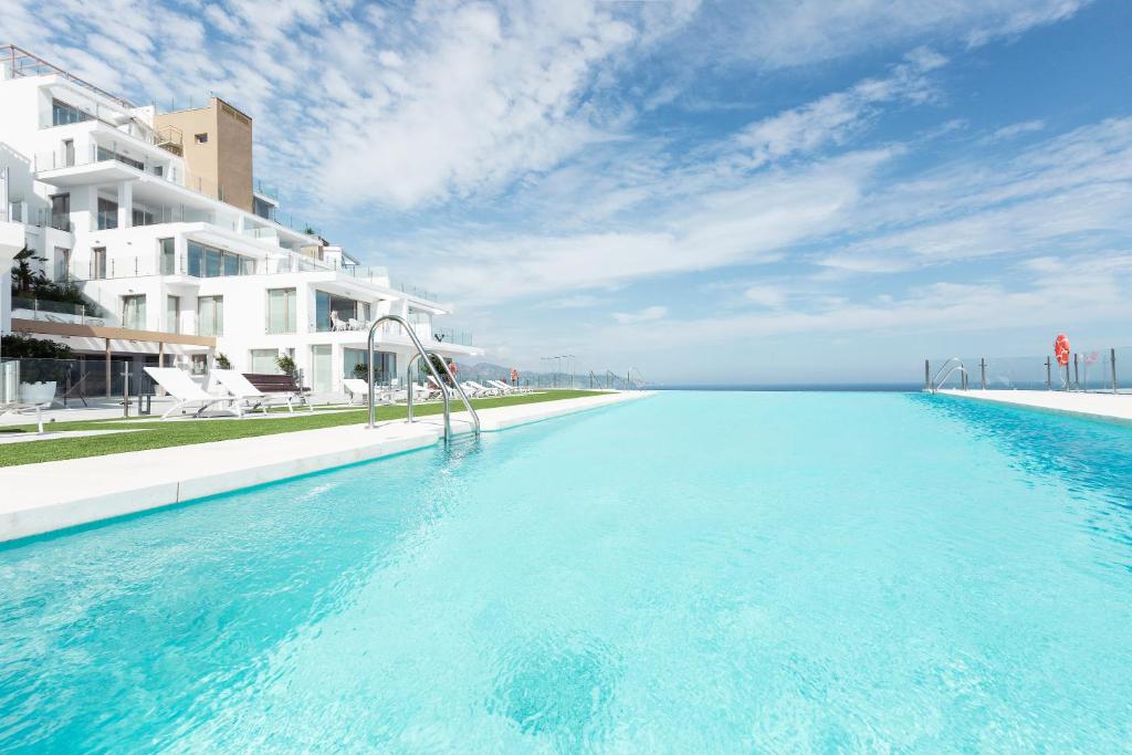 ein Pool neben einem großen weißen Gebäude in der Unterkunft Apartamentos Martalia Nerja in Torrox