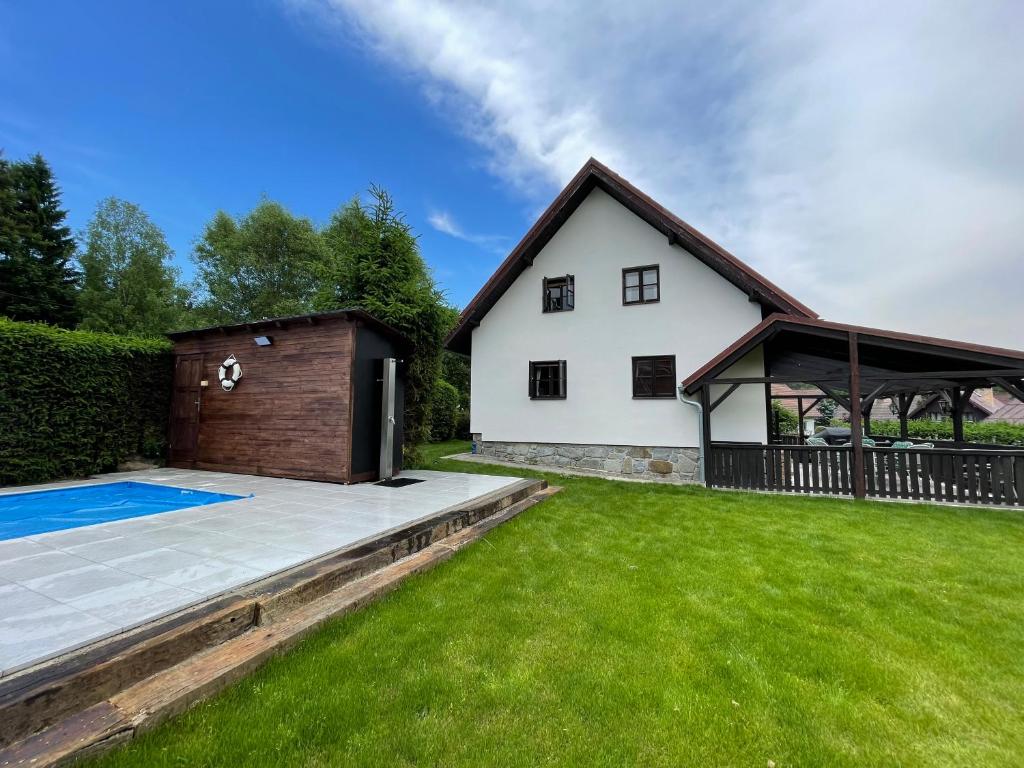 a house with a swimming pool and a building at Holiday house Lipno-Slupecna in Lipno nad Vltavou