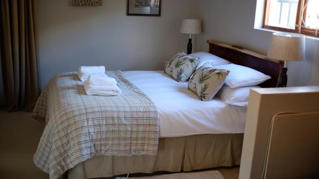 a bedroom with a bed with towels on it at Kuruma Farm Cottages in Worcester