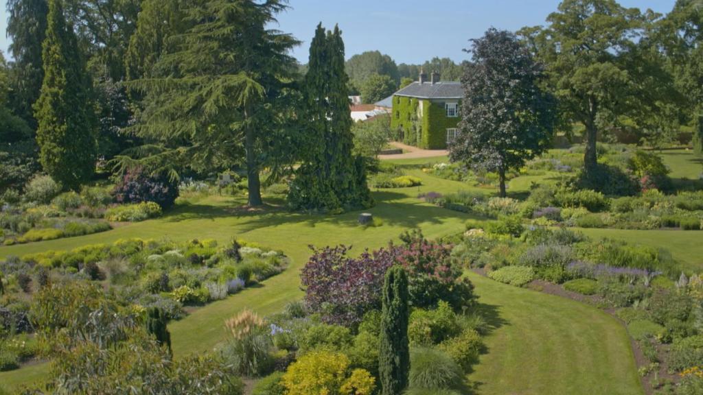 an aerial view of a garden with a house in the background at Bressingham Hall in Bressingham