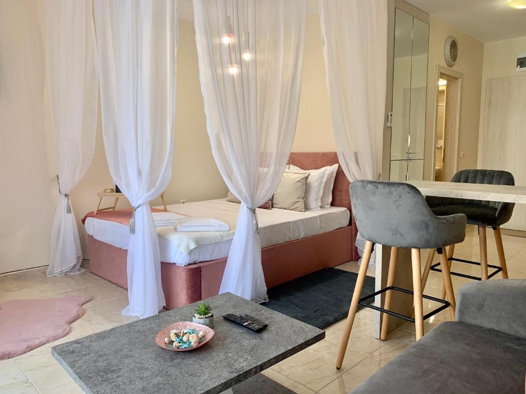 Zimmer mit einem Bett, einem Tisch und einem Stuhl in der Unterkunft Beige-a-view, Sea Dreams in Sweti Wlas