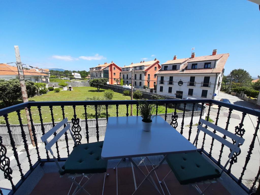 una mesa en un balcón con vistas a los edificios en Dunas de Corrubedo en Ribeira