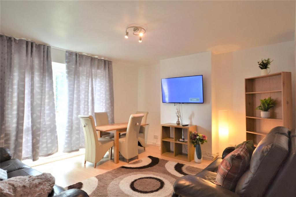 a living room with a table and a tv at London Zone 1 Lovely 3bedroom Maisonette Apartment in London