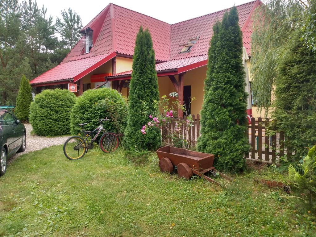 a house with a fence and a bike in the yard at Gospodarstwo Agroturystyczne na Mazurach in Jerutki