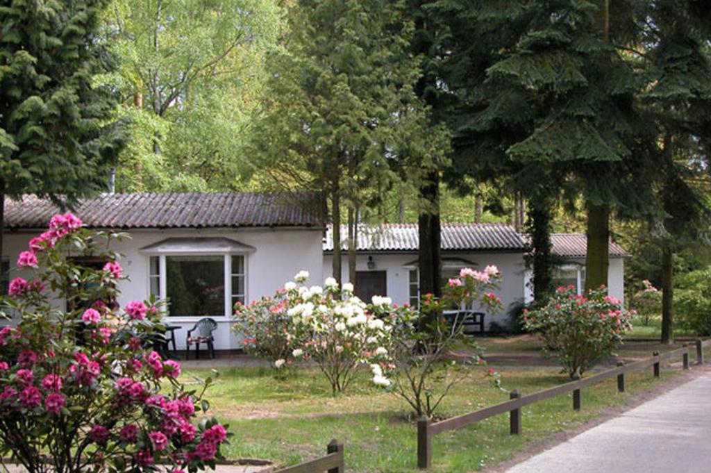 une petite maison blanche avec des fleurs devant elle dans l'établissement Ferienresort Damerow, à Ostseebad Koserow