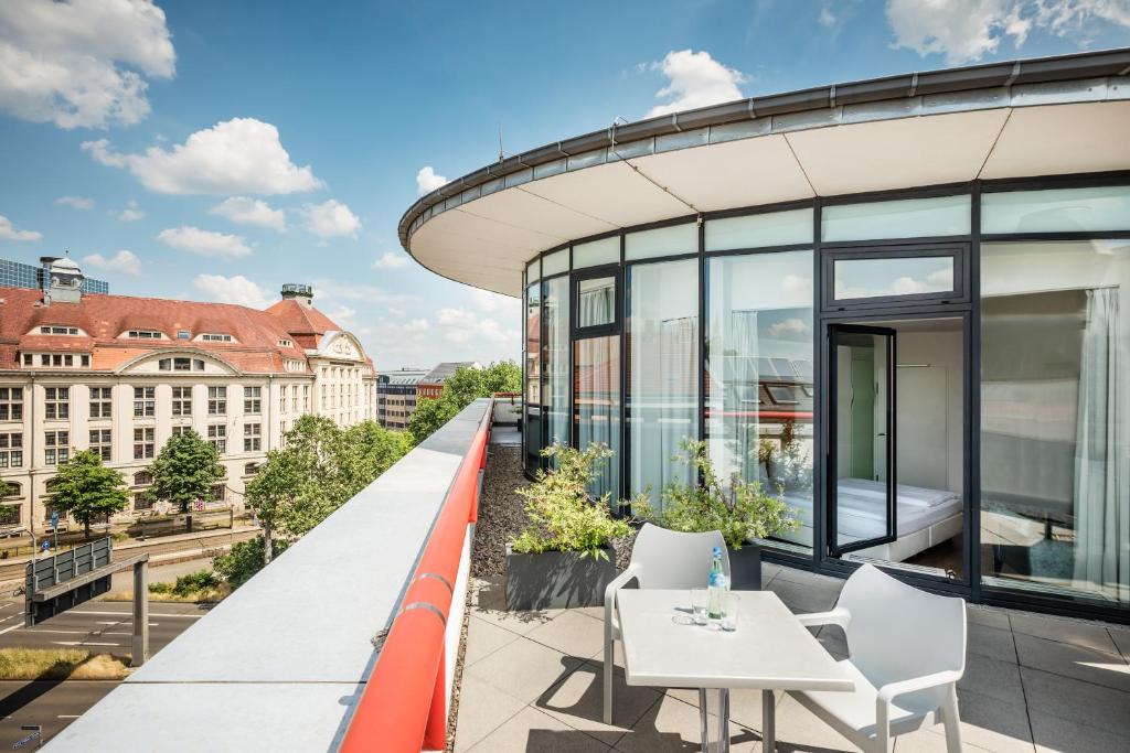 einen Balkon mit einem Tisch und Stühlen auf einem Gebäude in der Unterkunft Art Hotel City Leipzig in Leipzig