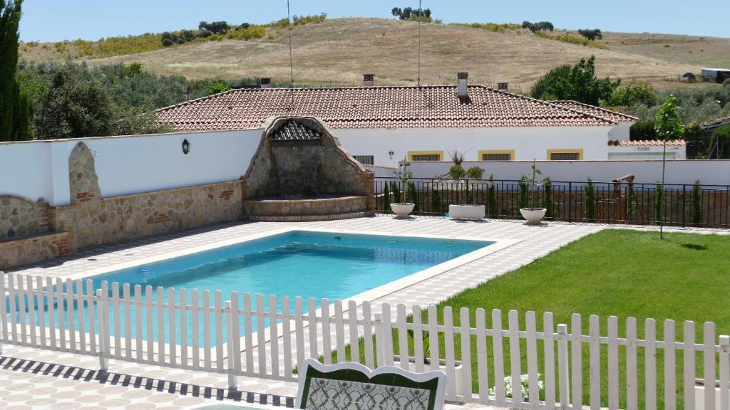 a swimming pool in a yard with a white fence at LA CASONA DE MANUELA in San Benito de la Contienda