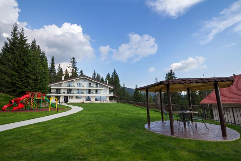 einen großen Hof mit Spielplatz und Gebäude in der Unterkunft Pensiunea Constantin in Ranca