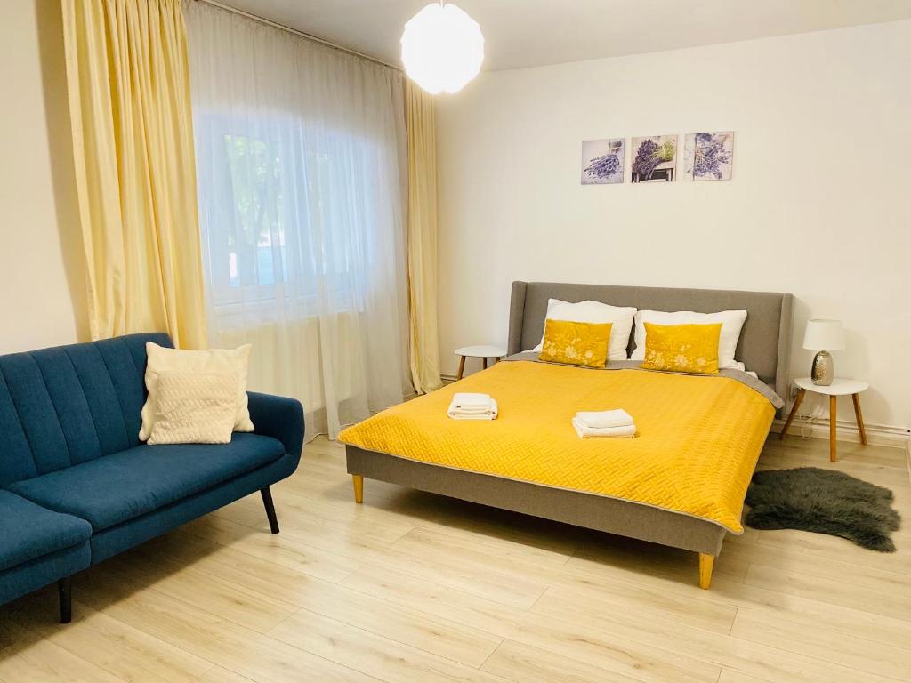 sypialnia z łóżkiem i niebieską kanapą w obiekcie AV Apartment w mieście Turda