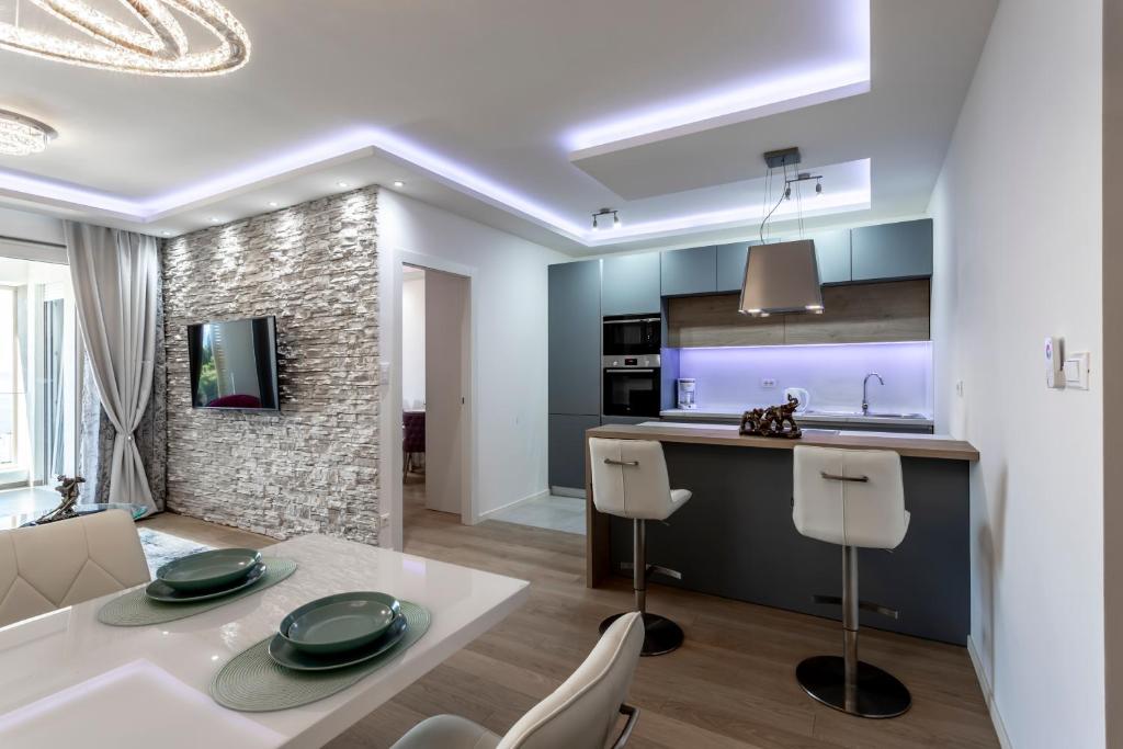 Il dispose d'une cuisine et d'un salon avec une table et des chaises blanches. dans l'établissement Luxury suite Elysium, à Split