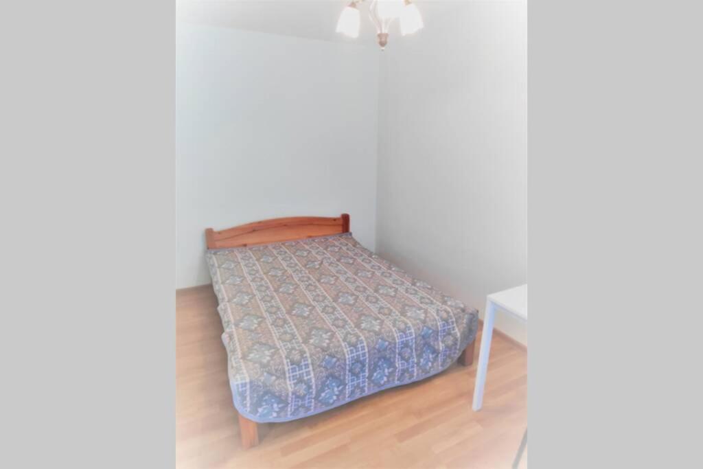 a small bedroom with a bed and a table at Dzīvoklis ģimenei 100 metri no jūras in Jūrmala