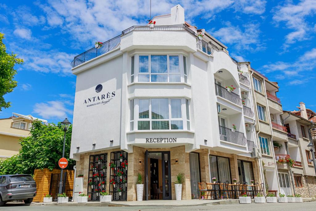 un edificio blanco con un cartel. en Antares City Sozopol en Sozopol