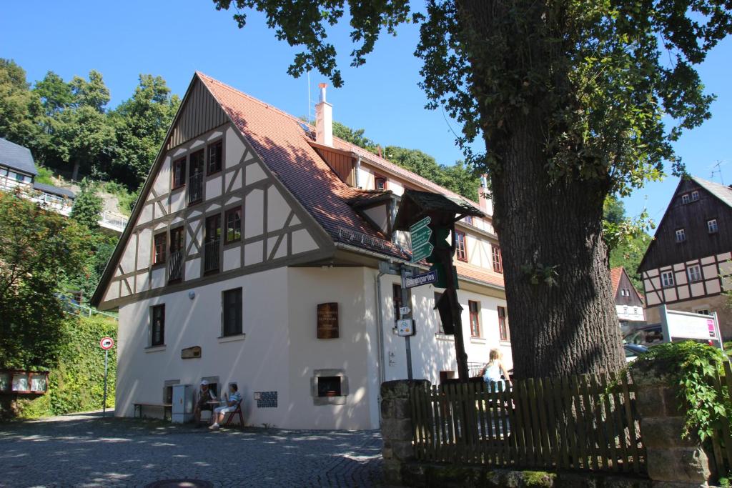 una casa blanca con techo marrón y árbol en Gesundheitshaus Hohnstein, en Hohnstein