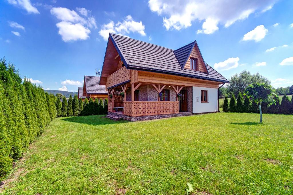 uma casa num grande campo relvado com árvores em Wilczy Jar Bieszczady em Bukowsko