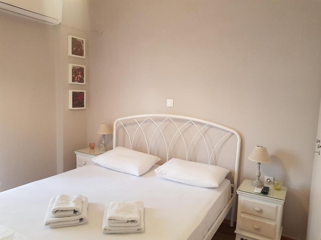a bedroom with a white bed with two towels on it at Fairytale house in Athens
