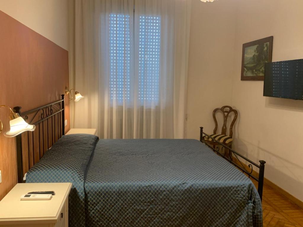 フィレンツェにあるDonatello Apartmentのベッドルーム1室(ベッド1台、テーブル、窓付)