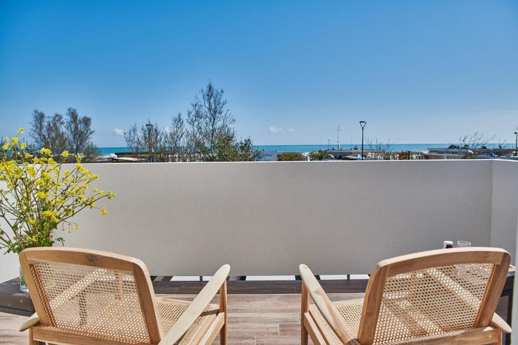 due sedie su un patio con vista sull'oceano sullo sfondo di Lu. b&b a Cervia
