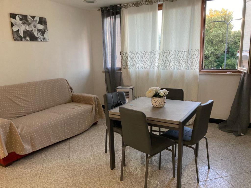 een woonkamer met een tafel en een bank bij Appartamento sulla piazza 90 m dal mare in Anzio