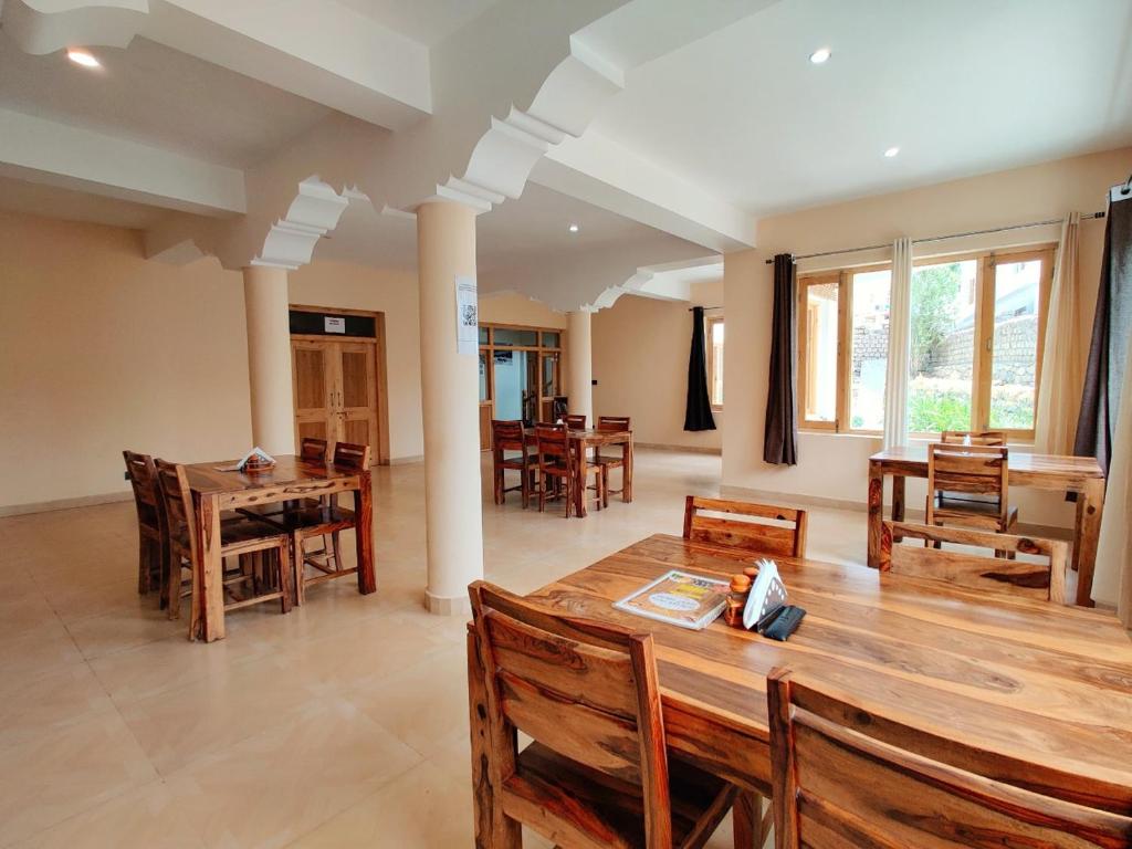 una sala da pranzo con tavolo e sedie in legno di Glacier View Guest House a Leh