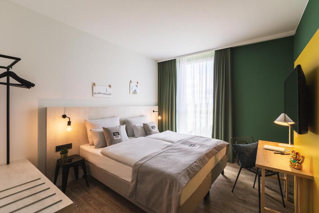 um quarto de hotel com uma cama grande e uma televisão em the niu Tab em Düsseldorf