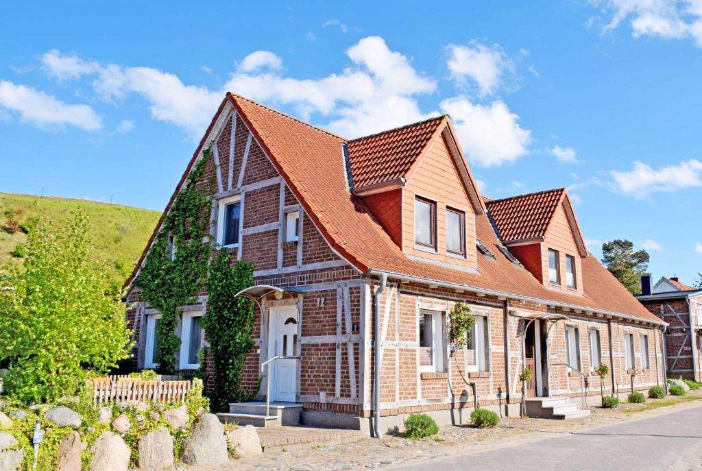 a large brick house with a red roof at Fewos 1 4 in Seedorf am Hafen Haus in Seedorf