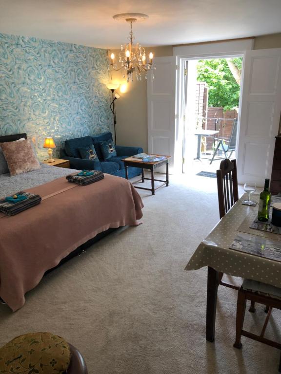 een slaapkamer met een bed, een bank en een tafel bij Little Treasure with up to 25 percent off ferry in Shanklin