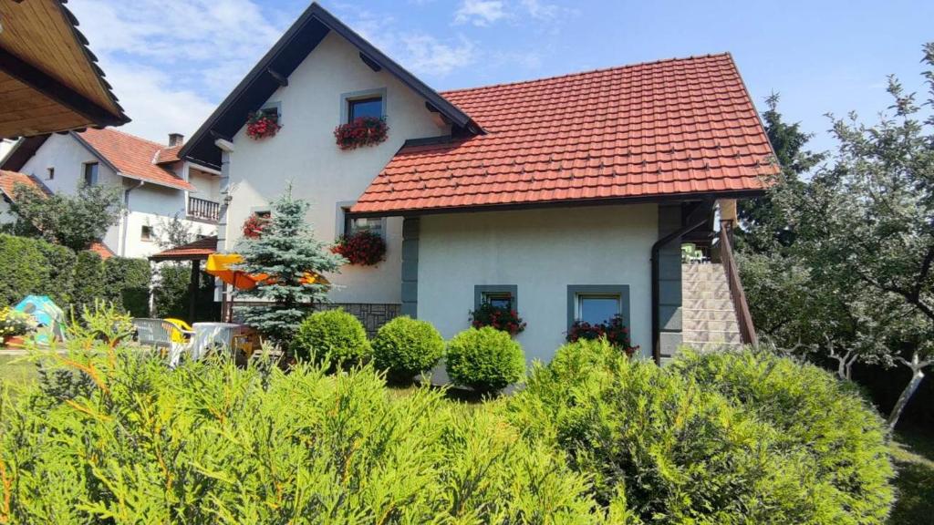 uma casa branca com um telhado vermelho em Privatni Smeštaj Tešević em Zlatibor