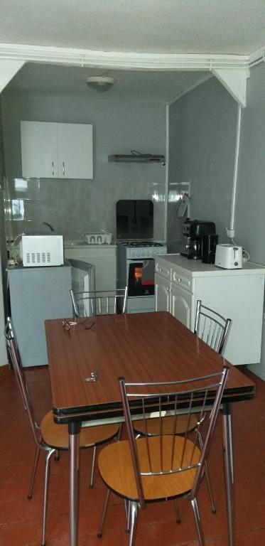 une cuisine avec une table et des chaises en bois ainsi qu'une table et une table dans l'établissement LE CREUSOT, au Creusot