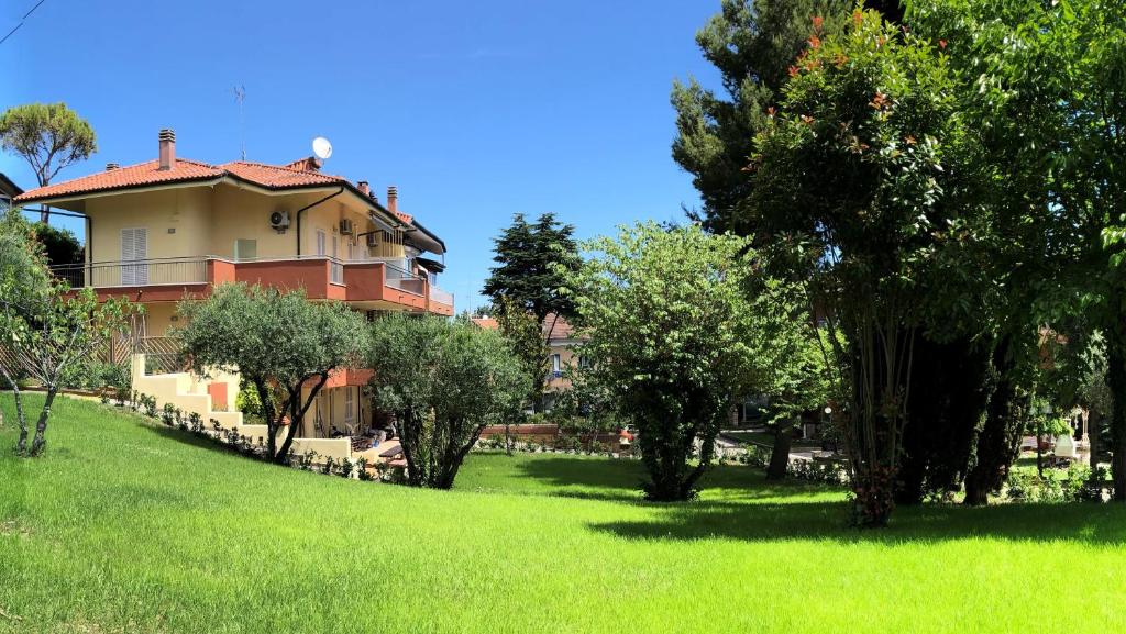 een huis op een heuvel met bomen in een veld bij Residenza VerdeMare in Misano Adriatico