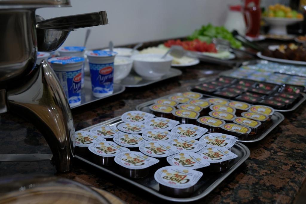 a counter topped with trays of cupcakes and other food at Eiffel Hotel in Batumi