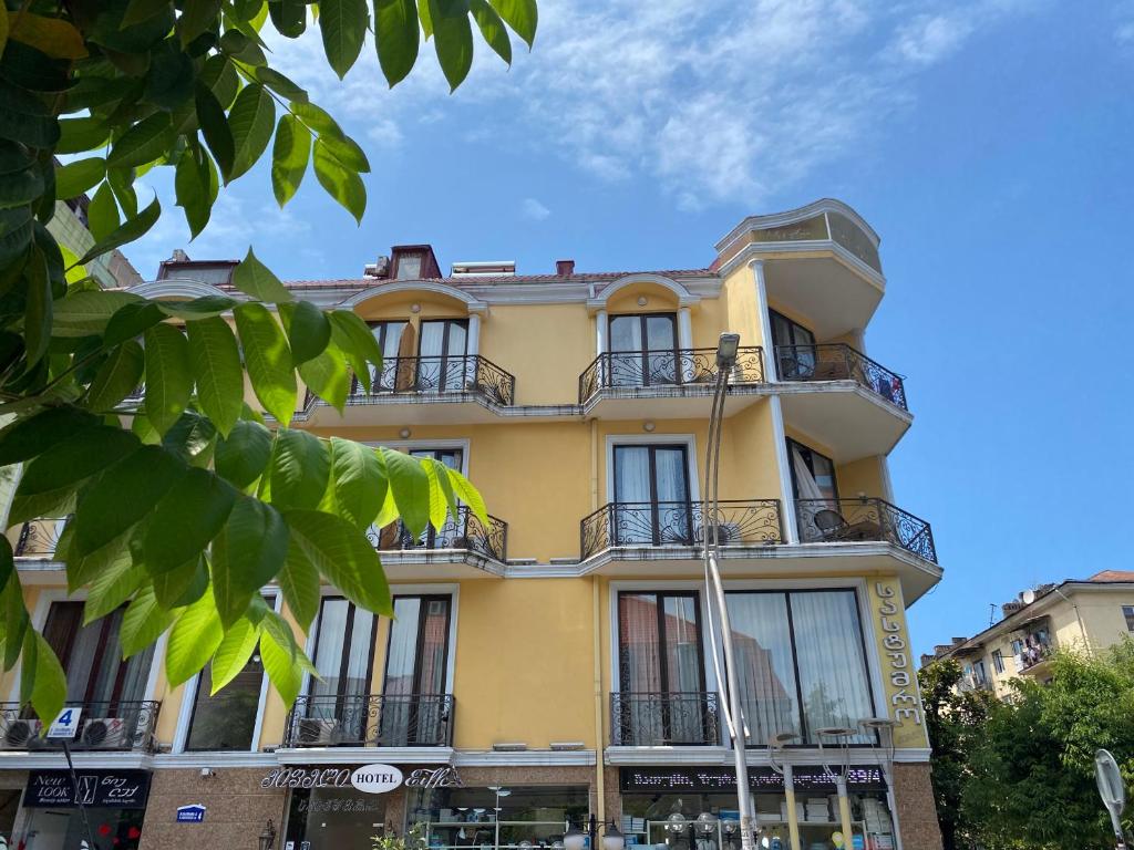 a yellow building with balconies on top of it at Eiffel Hotel in Batumi