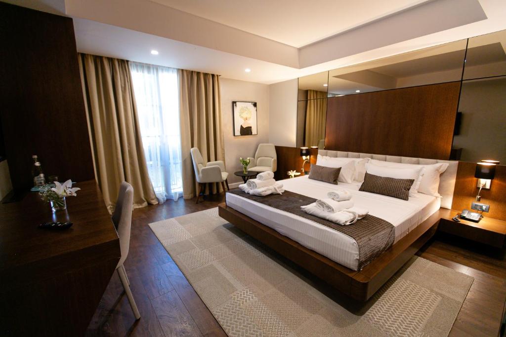 a bedroom with a large bed with a large mirror at Hotel Sokrati in Tirana