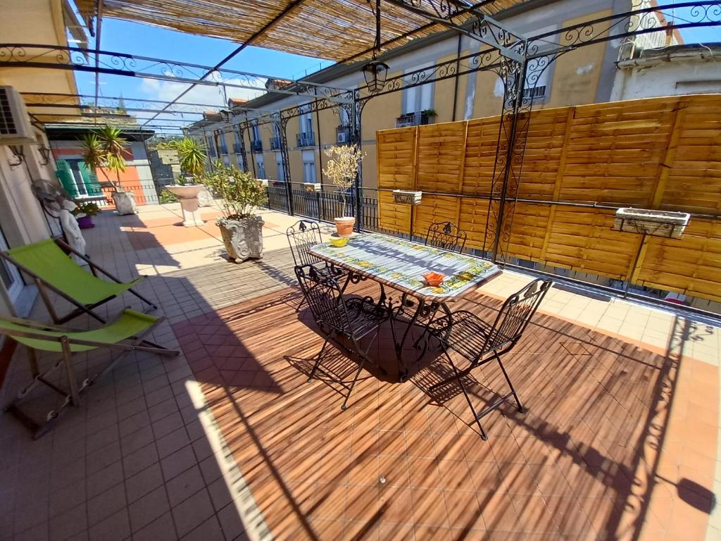 eine Terrasse mit einem Tisch und Stühlen auf einer Terrasse in der Unterkunft Accasatua Neapolitan Apartments in Neapel