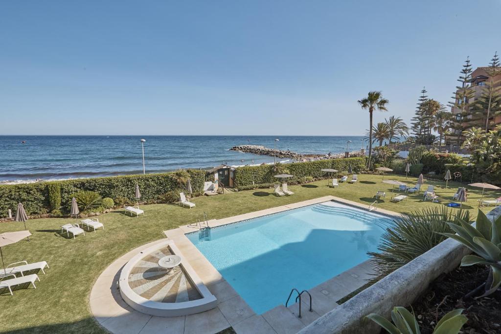 una piscina con el océano en el fondo en Seafront Apartment with 2 bedrooms in Puerto Banús, en Marbella