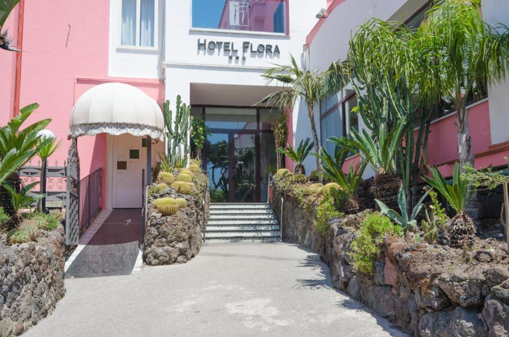 un bâtiment rose et blanc avec un mur en pierre dans l'établissement Hotel Flora Wellness & Beauty, à Ischia