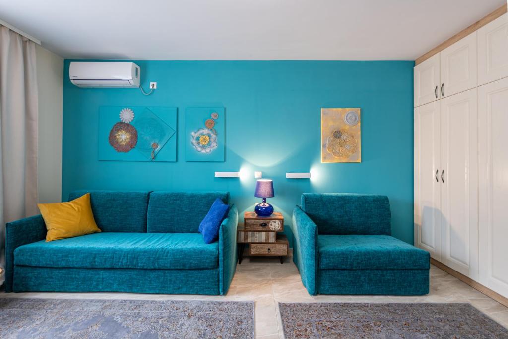 a blue living room with a couch and two chairs at Turquoise in Pomorie