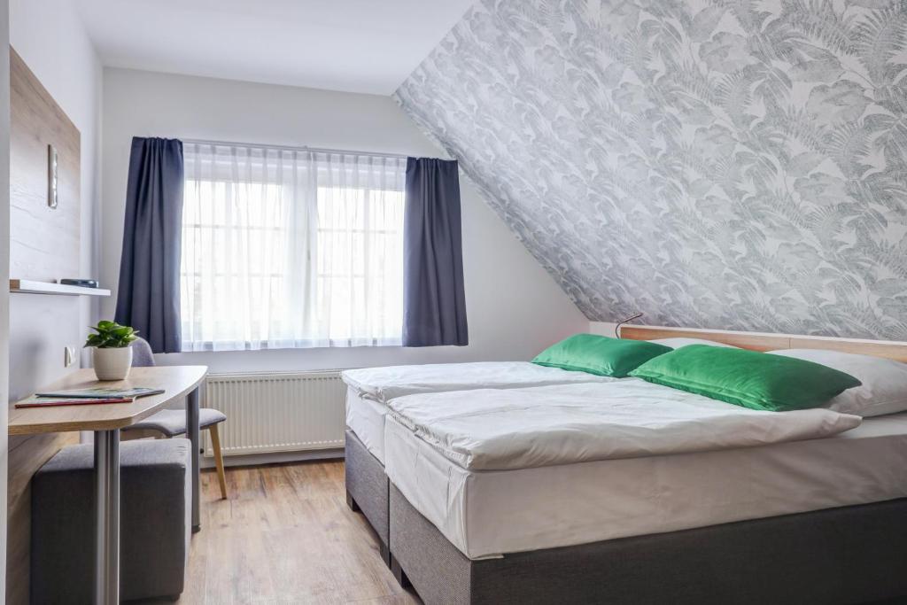 - une chambre avec un lit, une table et une fenêtre dans l'établissement Landhaus Schwerin, à Schwerin