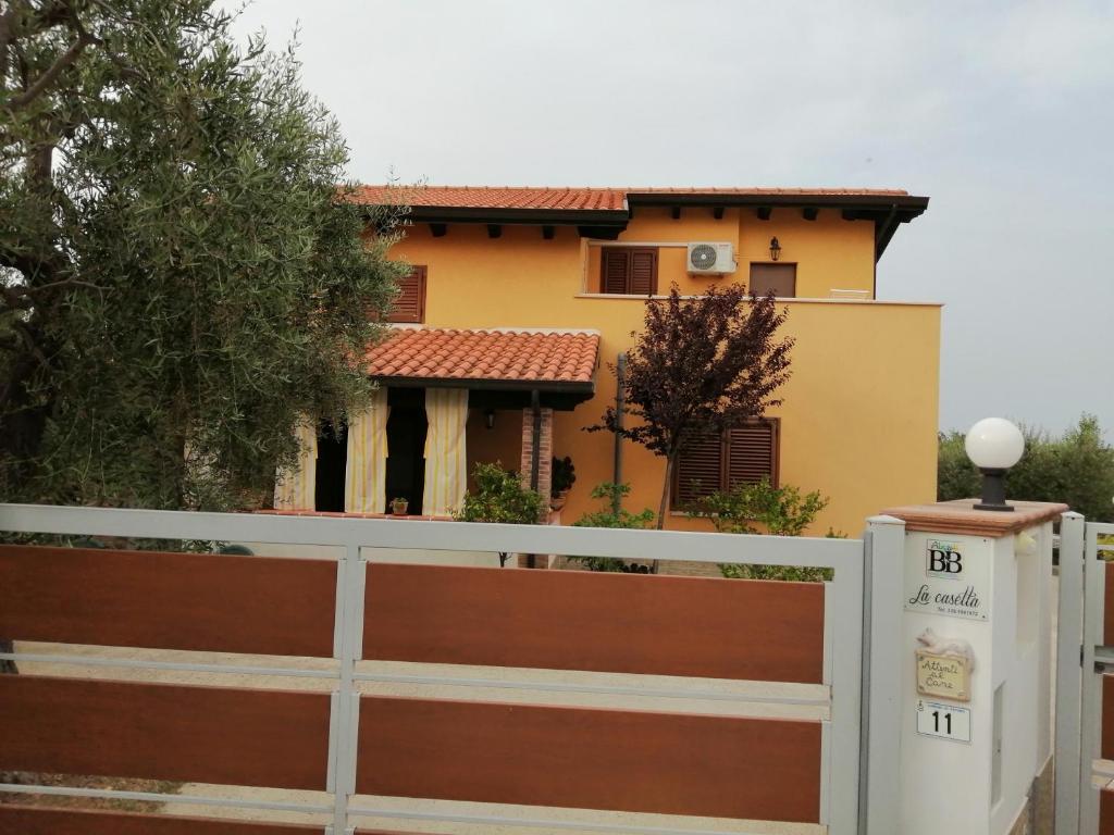 a fence in front of a house with a building at La casetta in Ortona