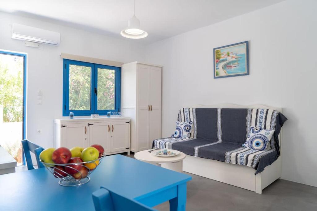 a living room with a bowl of fruit on a table at Blue Moon Apartments in Makry Gialos