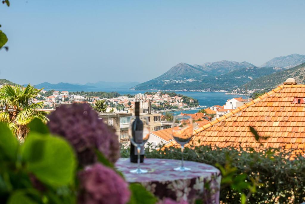 een tafel met een glas wijn bovenop een stad bij Apartments & Rooms Braticevic in Dubrovnik