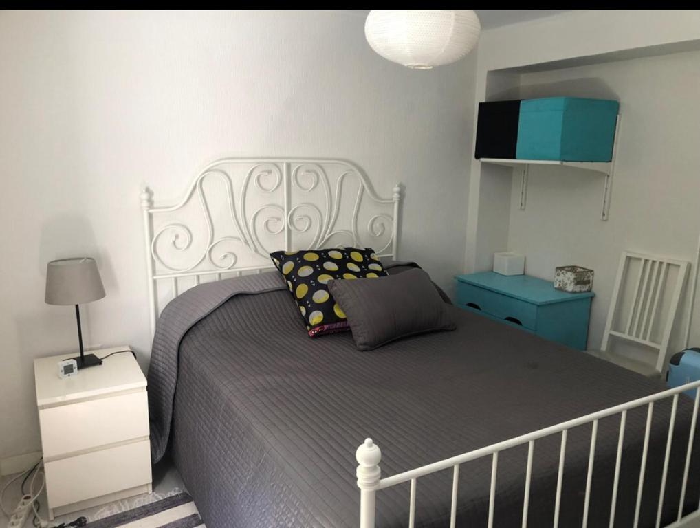 a bedroom with a large bed with a gray bedspread at Apartamento Luminoso y cómodo in Seville