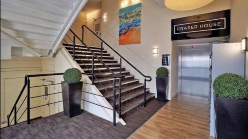 eine Lobby eines Hauses mit Treppe und Tür in der Unterkunft Heart Of Aberdeen City Centre 3 Bedrooms Apartment in Aberdeen