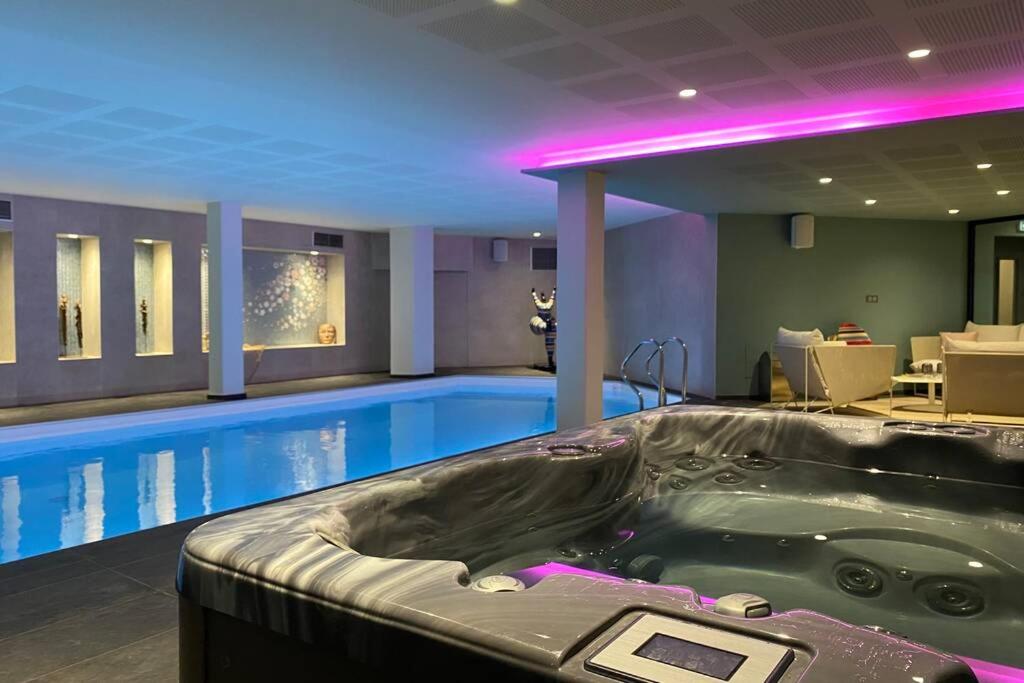 basen z wanną z hydromasażem w pokoju hotelowym w obiekcie Appartement d'exception avec vue mer w mieście Gicquel