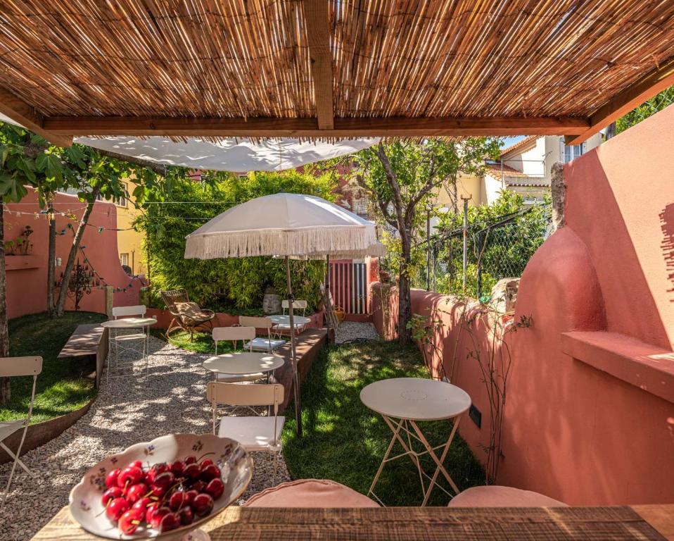 - une terrasse avec des tables et des chaises ainsi qu'une corbeille de fruits dans l'établissement toctoctoc lisboa, à Lisbonne